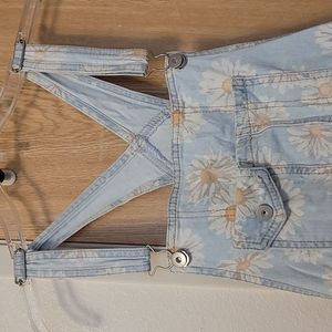 I am selling a light blue daisy short overalls with distressed look